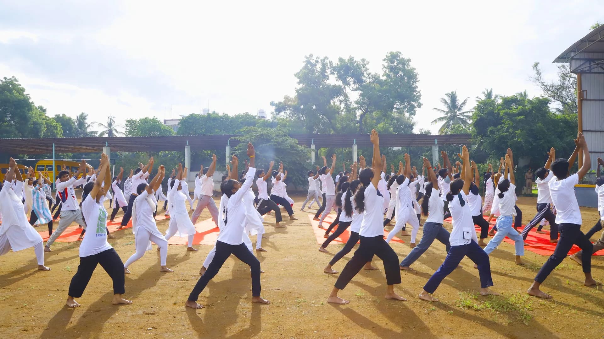 Students performing Virabhadrasana during mass yoga session at KSG College
