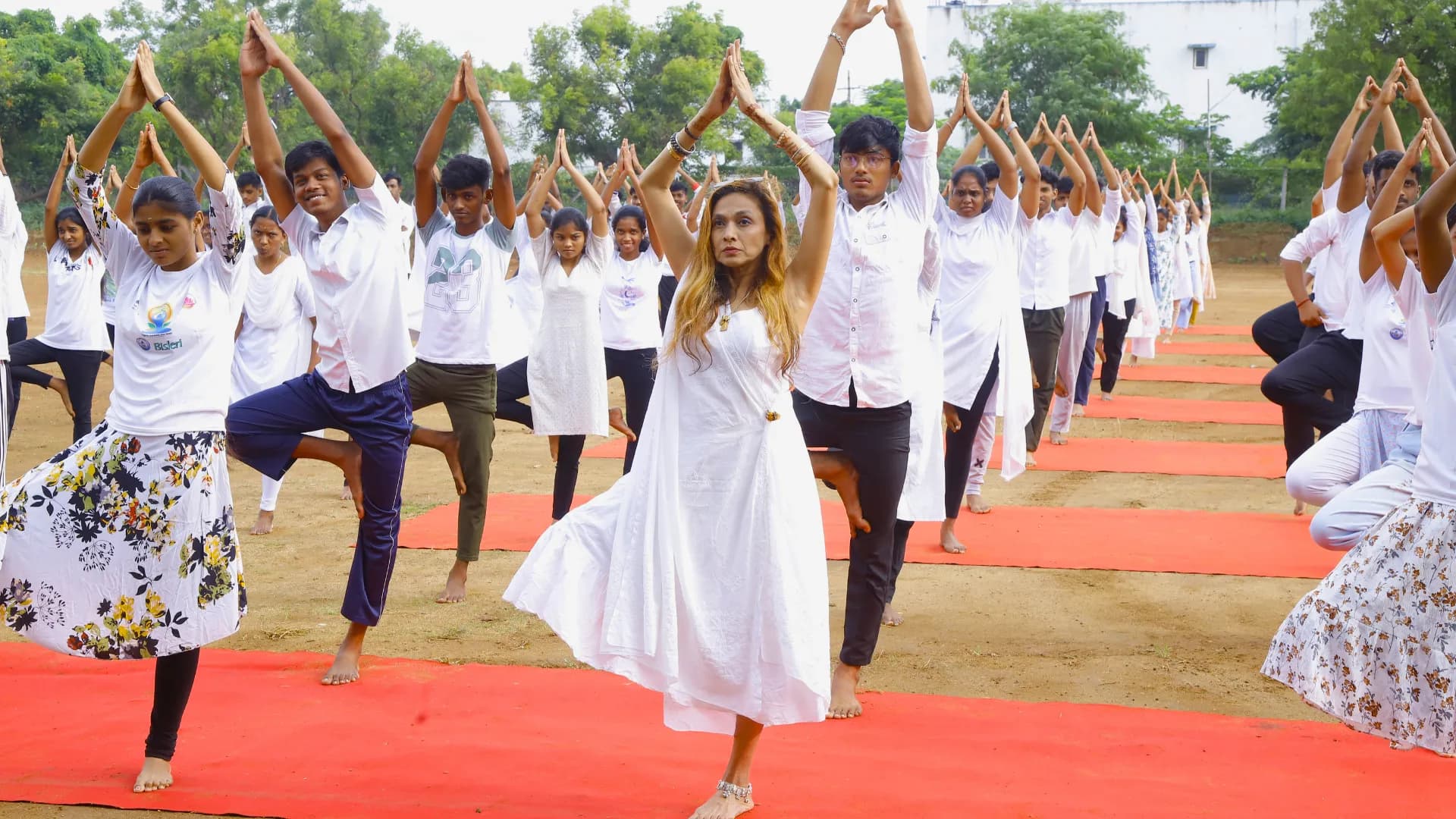 Expert yoga instructor demonstrating Vrikshasana with students